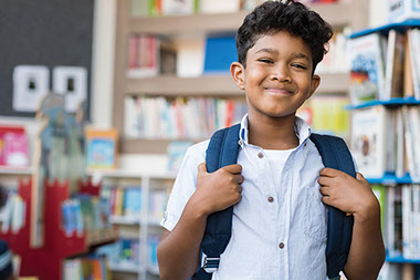 Smiling child with backpack on.