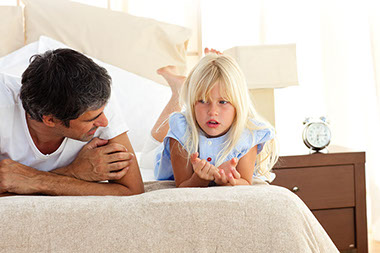 Image of father and young daughter talking.
