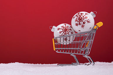 Small, mini shopping cart with 2 ornaments inside cart.