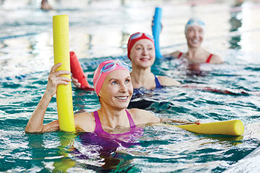 Three older women doing water exercises.