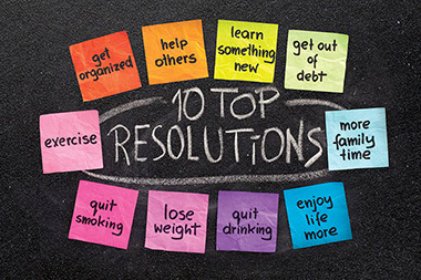 How to make those new year's resolutions stick. Image of top resolutions written on small paper notes.