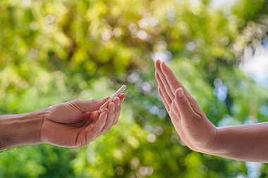 Image of hand refusing a cigarette.
