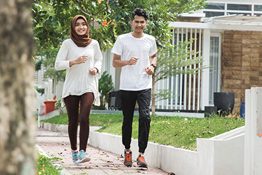 Couple jogging on side walk.