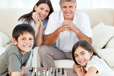 Image of family playing a game of chess.