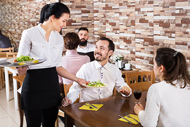 Waitress delivering food to table. Waitress delivering food to table.