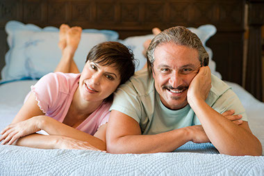 Image of smiling couple laying down.