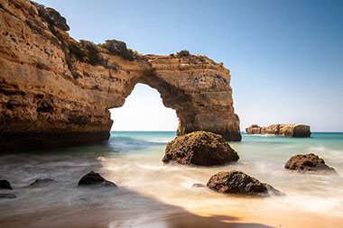 Ocean view of Stone Arch at Praia de Albandeira in Portugal.