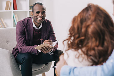 Smiling therapist talking to couple. Smiling therapist talking to couple.