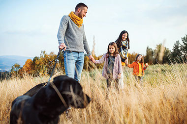 Family walking with pet dog.