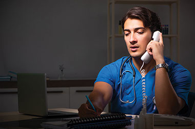 Doctor on phone working the night shift.