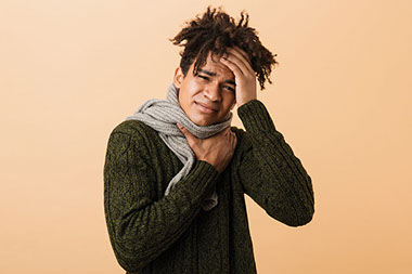 Man holding his throat and head.