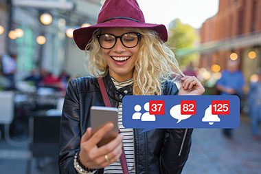 Smiling women on phone with social media icons showing activity.