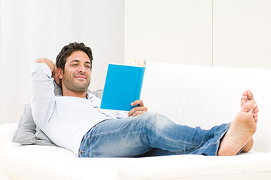 Image of man relaxing while reading a book.
