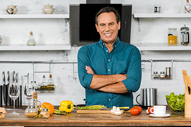 Middle aged man in kitchen about to prepare food.