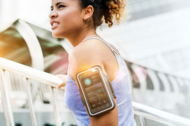 Active women with armband to hold smartphone.