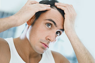 Image of man examining hair line.
