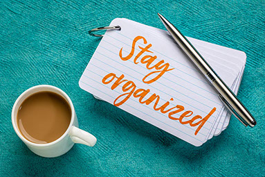 Notecard with "Stay Organized" written and a cup of coffee.