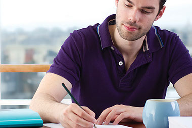 Tips for keeping a food diary. Image of young man writing in a journal.