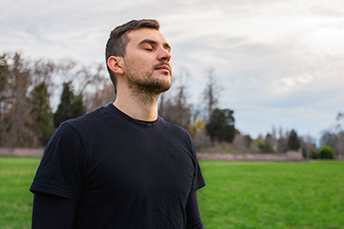 Man with eyes closed taking deep breaths.