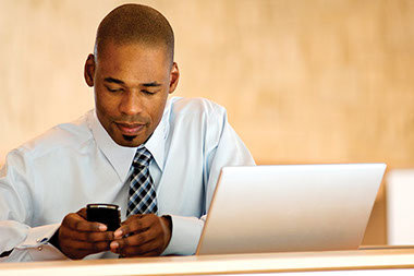 Avoid the aches and pains of technology. Image of business man with laptop and smart phone.