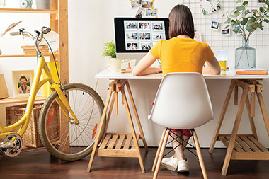 Women sitting at desk working on computer.