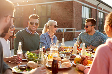 Group of friends sitting outside eating at a restaurant.
