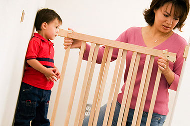 Image of mom placing a safety gate on stairs.