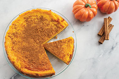 Sweet potato cheesecake with a couple pieces missing.