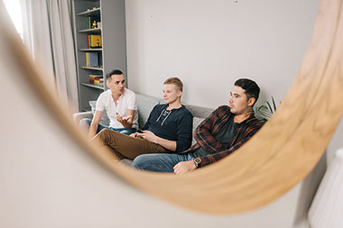 Reflection in mirror of three friends.