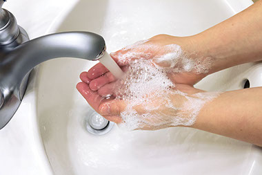 Image of hands being washed with water and soup.
