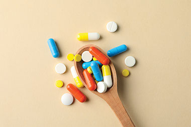Wooden spoon filled with variety of pills. Wooden spoon filled with variety of pills.