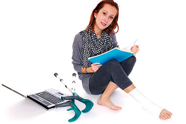 Image of young women with a broken ankle, studying.
