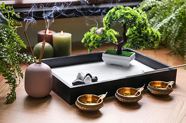 Table top zen garden with candles and burning incense.