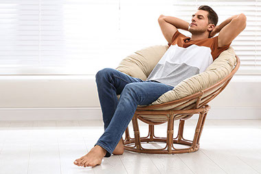 Man resting in circle chair.