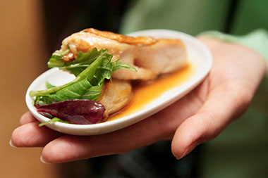 Image of small plate with food in palm of hand.