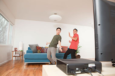Image of two males playing active video game, such as the Wii.