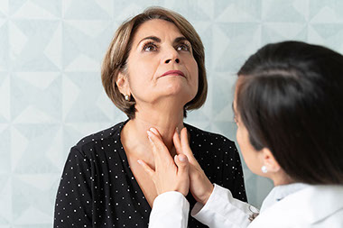 Doctor examining women's neck.