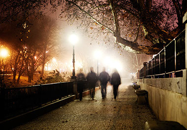 Image of people walking/jogging in the dark.