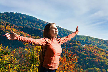 Female standing outside with arms open taking in the fresh air. Female standing outside with arms open taking in the fresh air.