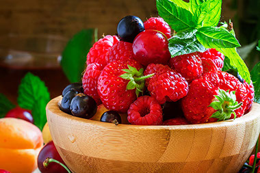 A wooden bowl filled with berries.