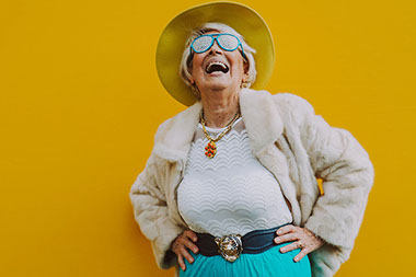 Older women laughing and wearing fun, funky sunglasses.