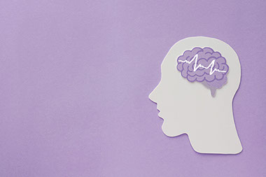 Purple background with paper cut out of head and brain. Purple background with paper cut out of head and brain.