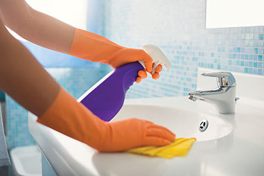 Help for the indoor sneezing season. Image of a person cleaning the bathroom sink.