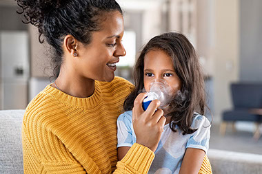 Mom helping child with a breathing treatment.