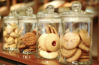 Image of cookie jars lined up with cookies in them. Image of cookie jars lined up with cookies in them.