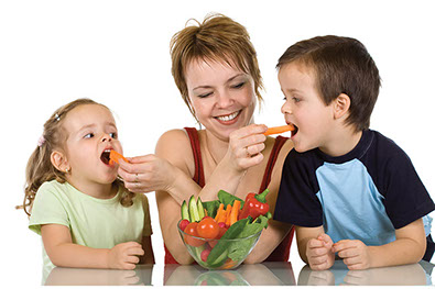 Image of mother feeding 2 young kids carrots.