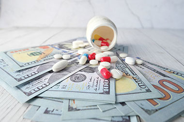 Pills and bottle on top of a money. Pills and bottle on top of a money.