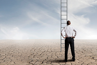 How do you define success? Image of a business man looking up at an endless ladder.