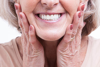 Close up image of a mature women smiling showing her dentures.