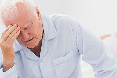 Image of older man sitting on bed. Image of older man sitting on bed.